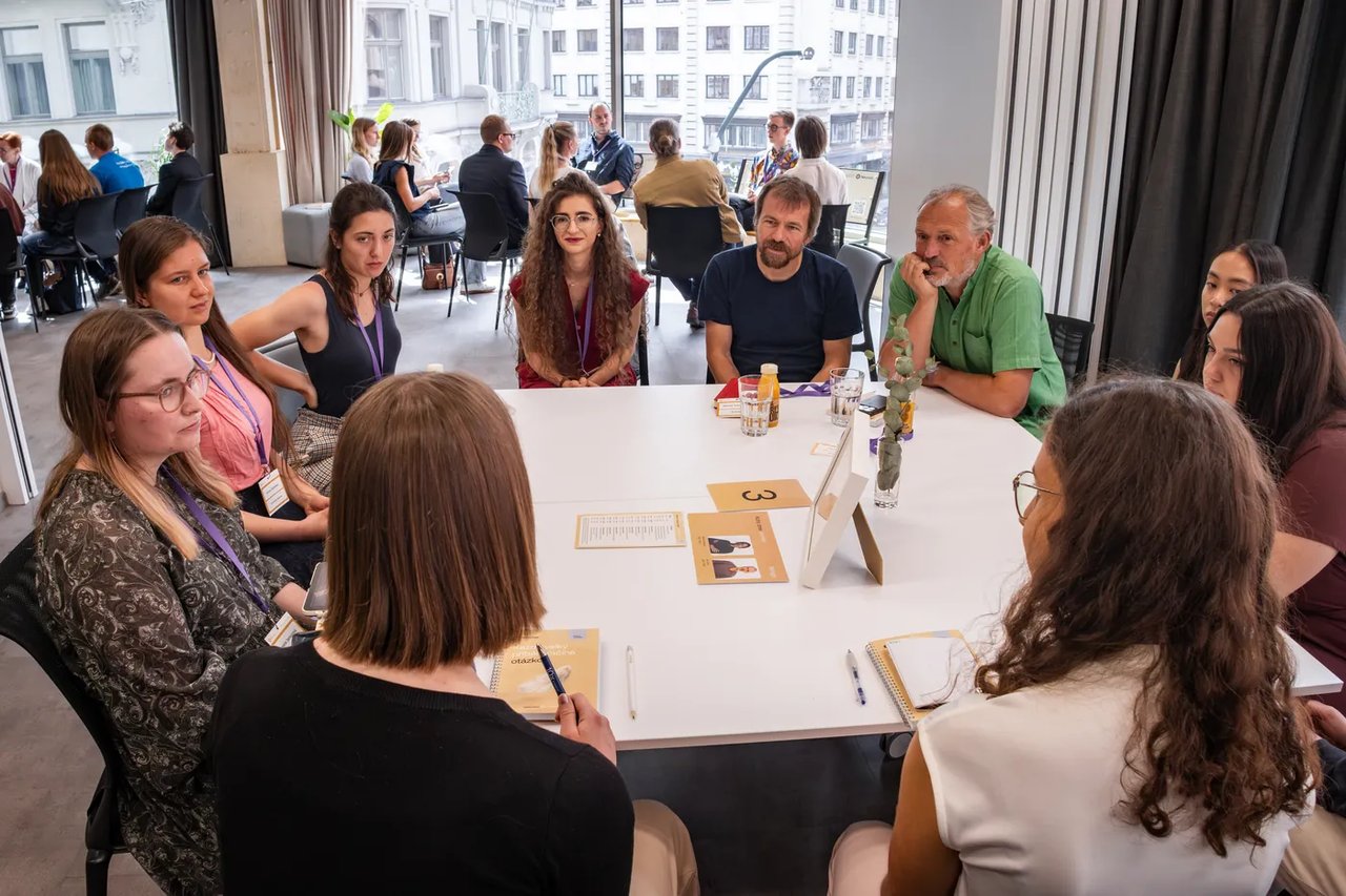 Students at a table with a scientist at a Neuron Junior event
